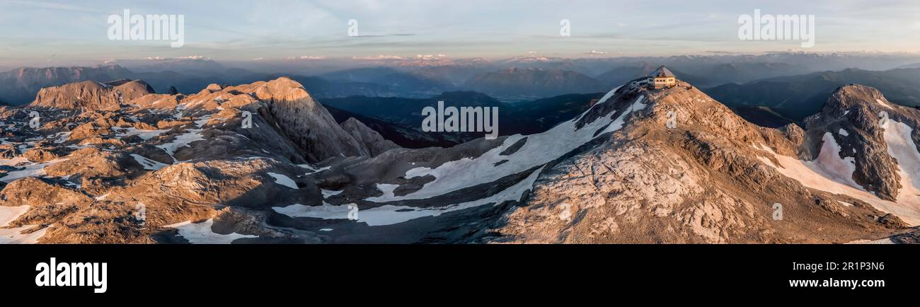 Vue aérienne, panorama alpin, vue sur le plateau rocheux avec neige et glacier au lever du soleil, dans la cabane de montagne en arrière-plan Matrashaus à Hochkoenig Banque D'Images