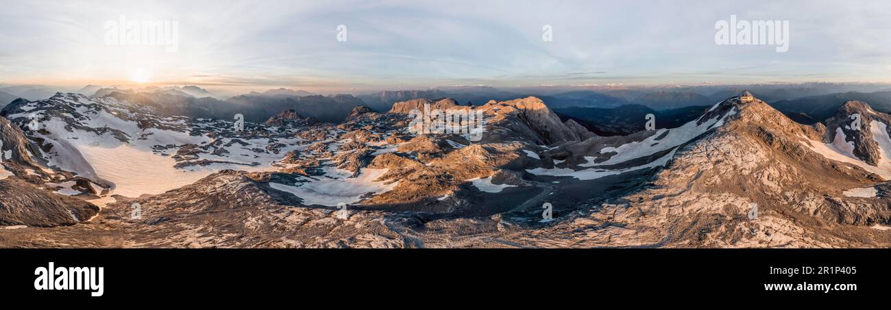 Vue aérienne, panorama alpin, vue sur le plateau rocheux avec neige et glacier au lever du soleil, dans la cabane de montagne en arrière-plan Matrashaus à Hochkoenig Banque D'Images