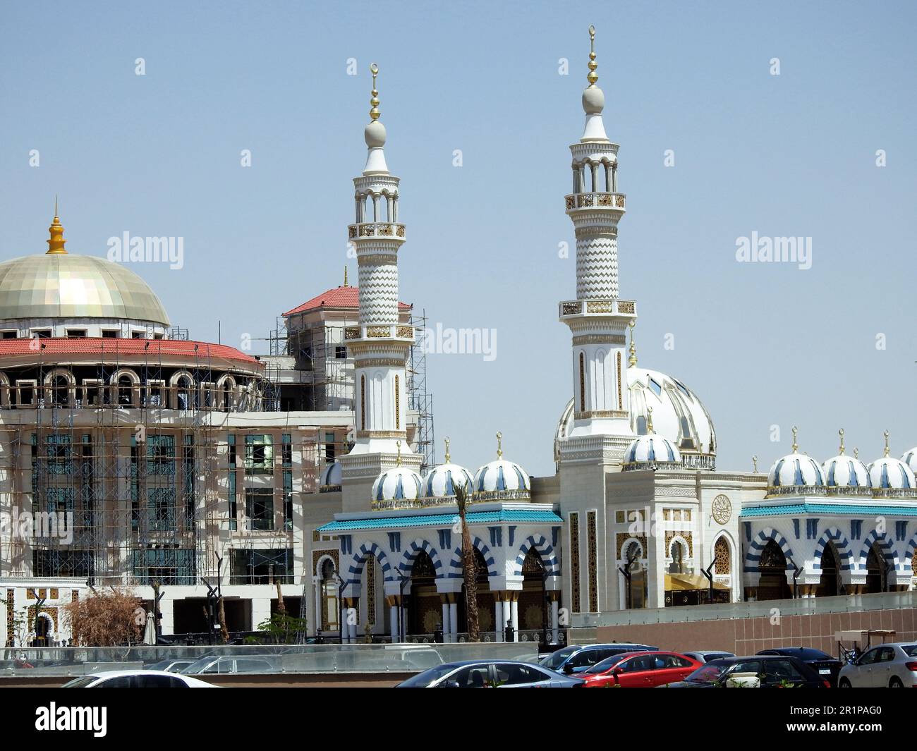 Le Caire, Egypte, 26 avril 2023: Une belle mosquée blanche dans le Nouveau Caire Egypte avec de multiples dômes et minarets à côté d'un bâtiment en construction avec un Banque D'Images