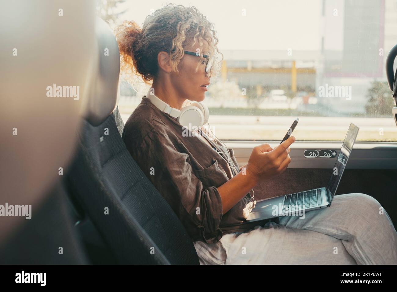 Femme d'affaires voyageant sur le service de transport de bus transfert et écrire des messages sur le téléphone mobile. Une femme moderne lisant la notification sur un téléphone portable assis à l'intérieur d'un véhicule de bus. Voyages et style de vie professionnel Banque D'Images