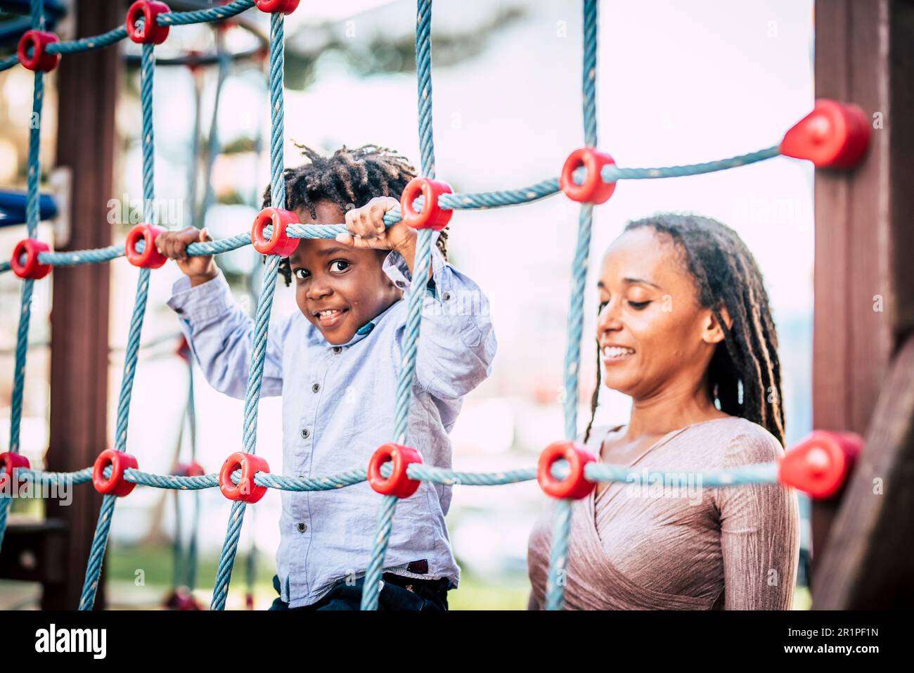 Mère et fils noirs qui s'amusent ensemble au parc de jeux. Maman et les enfants rient et sourient à l'extérieur Banque D'Images