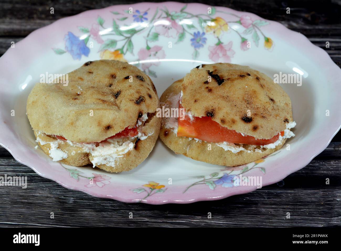 Fromage blanc feta avec tranches de tomates à l'intérieur d'un mini pain plat traditionnel égyptien avec son de blé et farine, petit Aish Baladi ou petit pain ba Banque D'Images