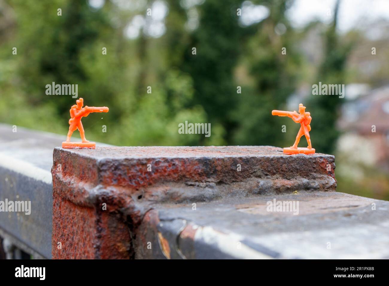 Des soldats miniatures en plastique orange collés à un parapet de pont sur le sentier de randonnée de Parkland à North London, Royaume-Uni Banque D'Images