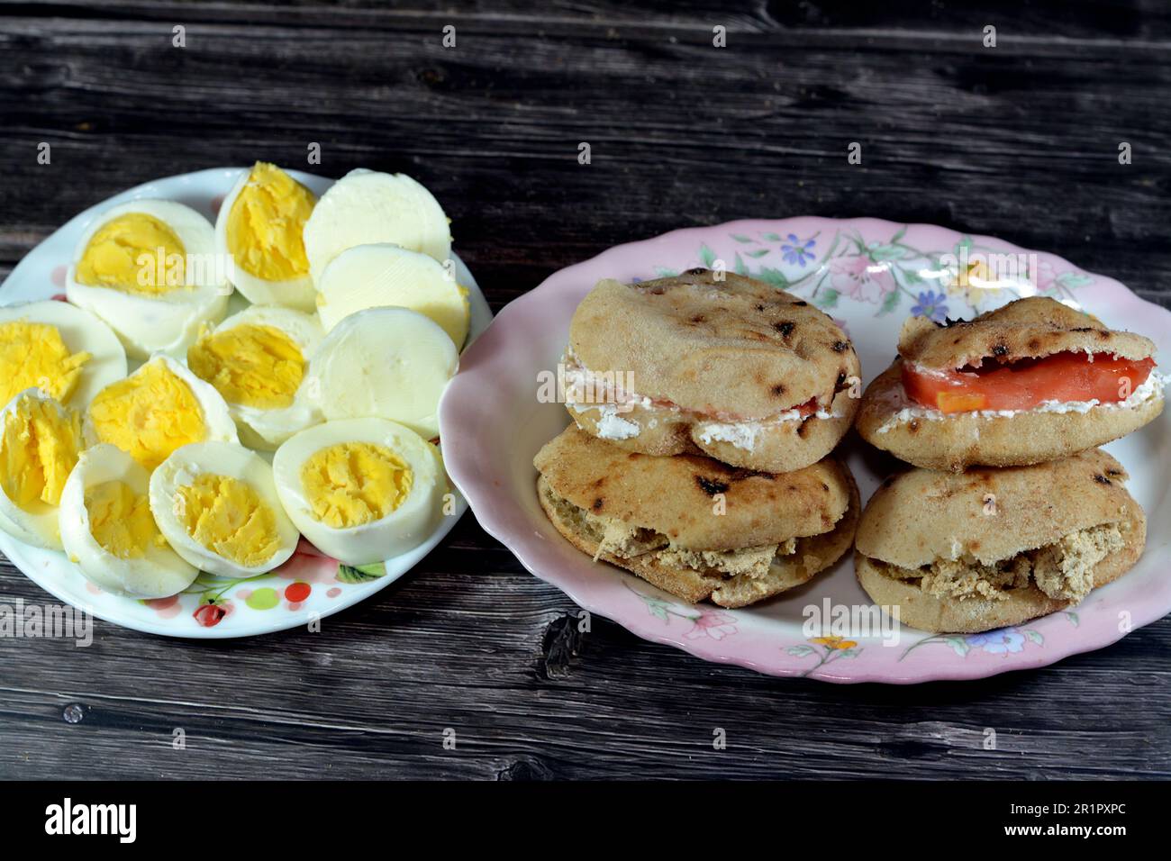 Une assiette de tranches d'œufs durs et de sandwiches au fromage blanc Feta avec des tranches de tomates et des tahini halva ou Halawa Tahiniya Banque D'Images