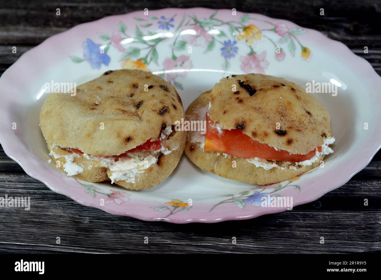 Fromage blanc feta avec tranches de tomates à l'intérieur d'un mini pain plat traditionnel égyptien avec son de blé et farine, petit Aish Baladi ou petit pain ba Banque D'Images