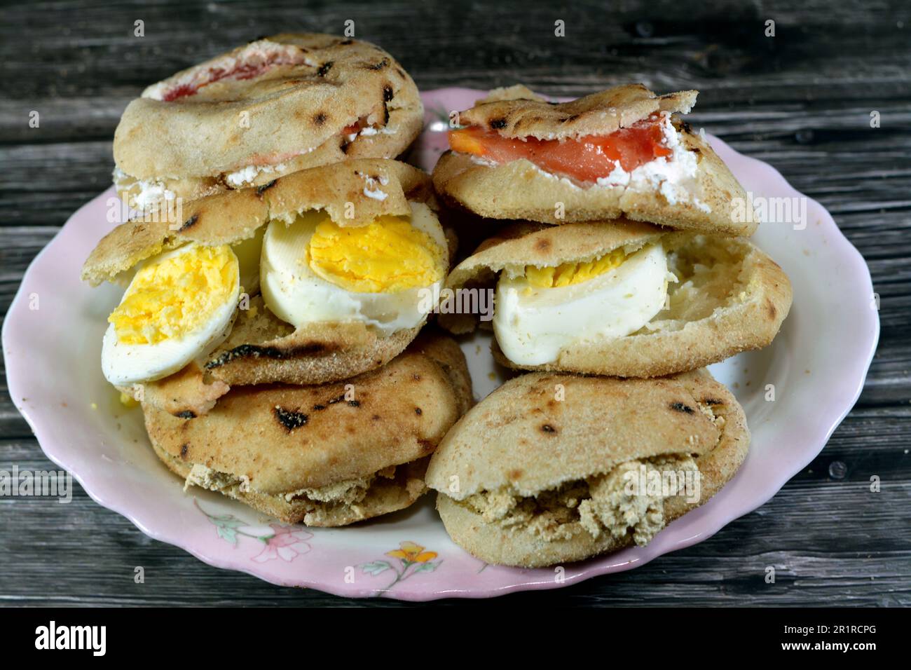 Une assiette de sandwiches au fromage blanc Feta avec des tranches de tomates, de la tahini halva traditionnelle ou Halawa Tahiniya et des tranches d'œufs durs insi Banque D'Images