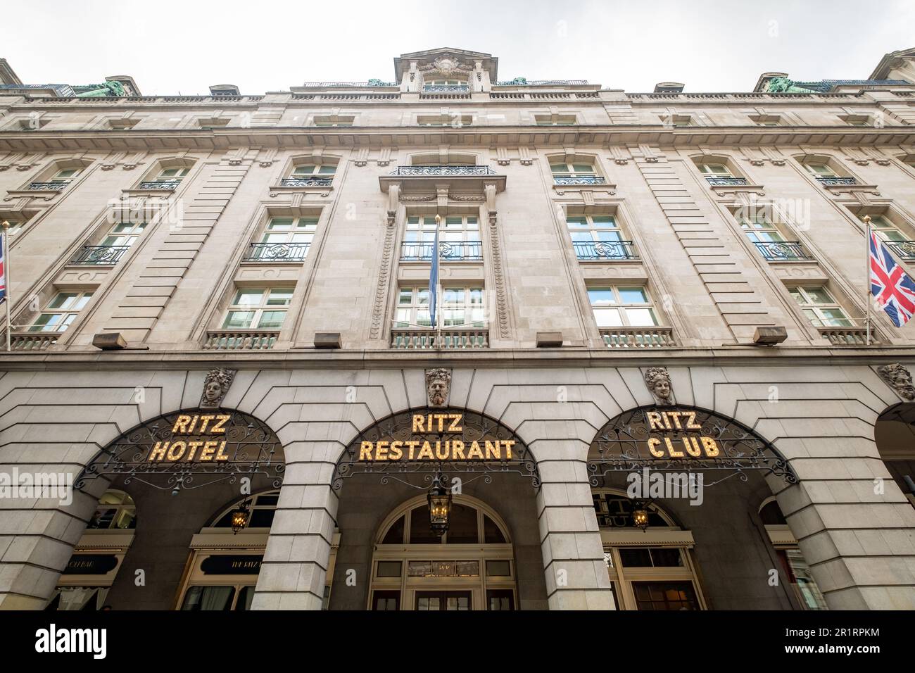 Londres - 2023 mai : l'hôtel de luxe 5 étoiles Ritz London avec les célèbres taxis noirs londoniens se déplace de façon floue devant l'entrée principale. Banque D'Images