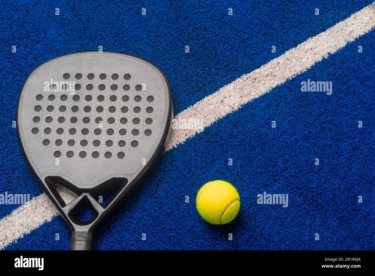 Raquette et balle de paddle-tennis professionnelle noires sur fond bleu. Affiche sur le thème du sport horizontal, cartes de vœux, en-têtes, site Web et application Banque D'Images