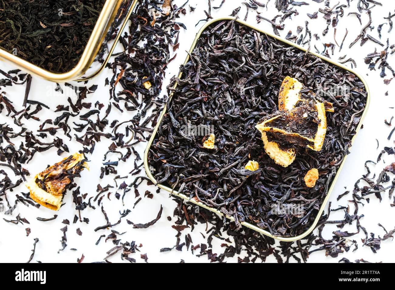 plat lay gros plan sur le thé noir à feuilles d'orange sec dans la boîte de la boîte et renversé sur la table blanche Banque D'Images plat lay gros plan sur le thé noir à feuilles d'orange sec dans la boîte de la boîte et renversé sur la table blanche Banque D'Images