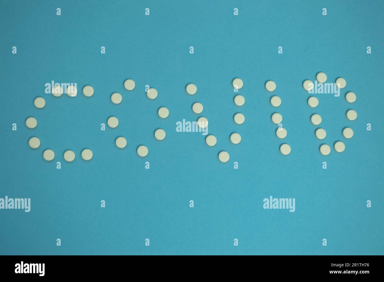 les médicaments sont présentés sous forme de coronavirus. pilules blanches sur fond bleu. Moyens de renforcer l'immunité contre la désea infectieuse Banque D'Images
