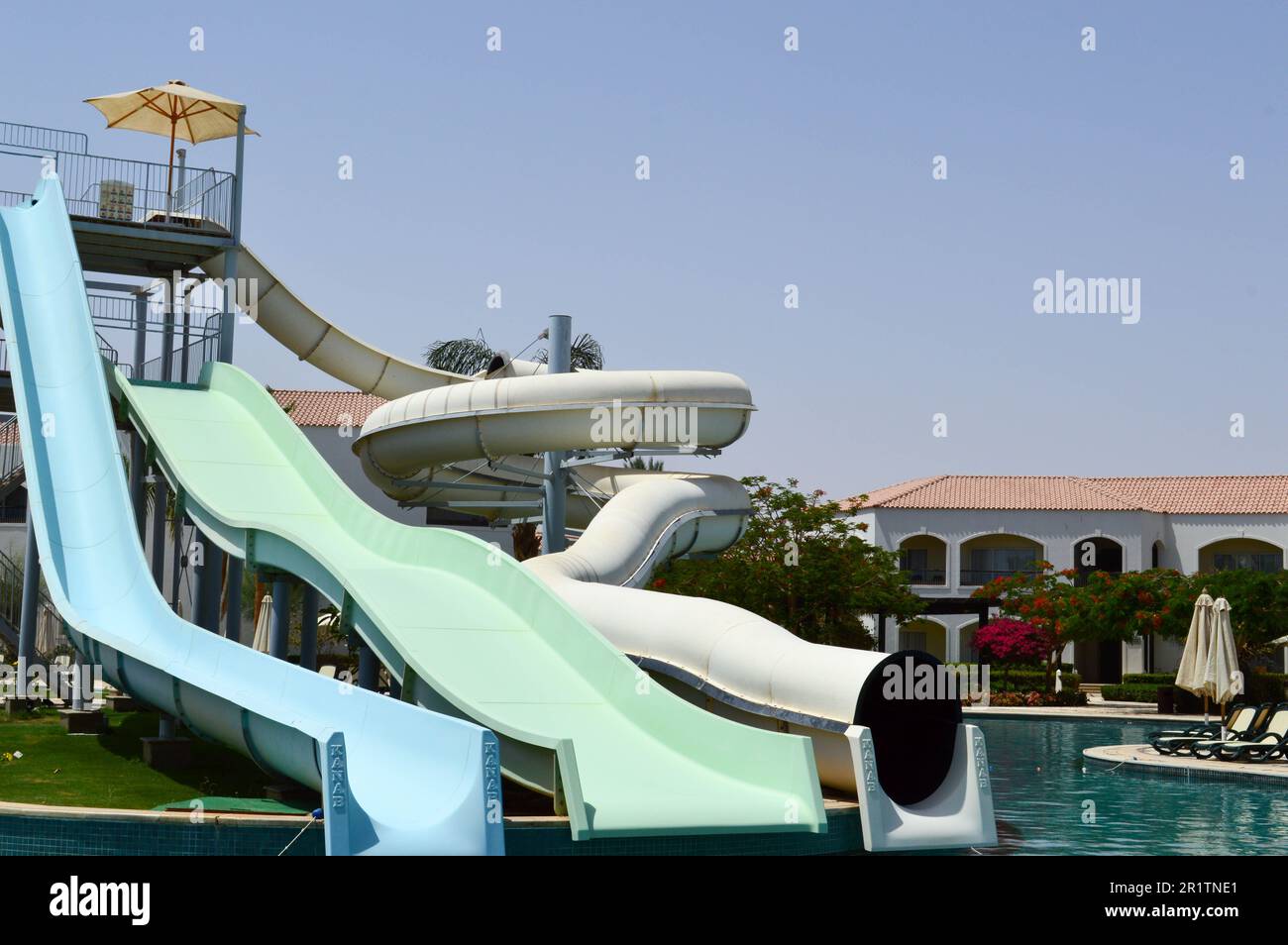 Piscine extérieure avec eau chaude bleue claire et toboggans aquatiques