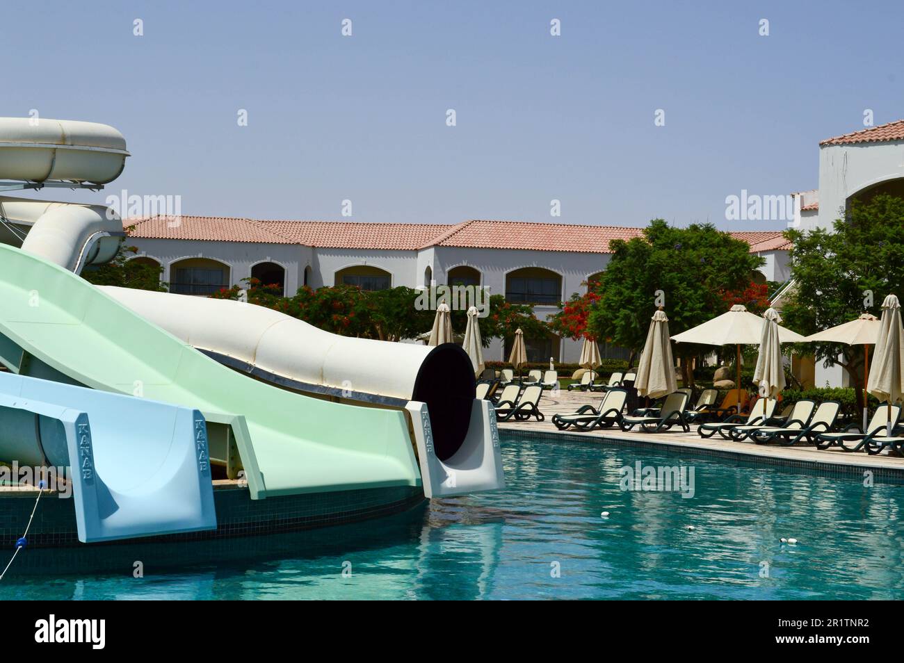 Piscine extérieure avec eau chaude bleue claire et toboggans aquatiques