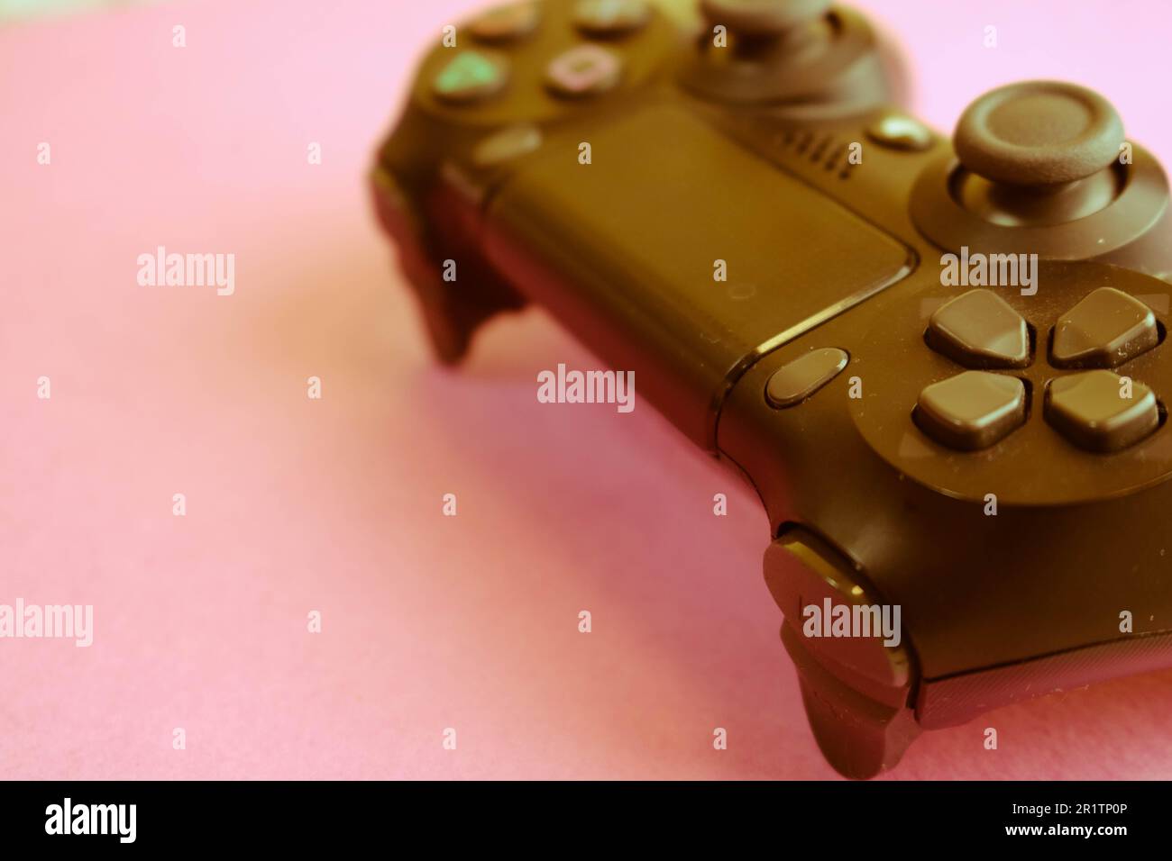 Un beau joystick de jeu numérique noir moderne pour contrôler une console de jeu vidéo pour les jeux vidéo avec des boutons et des touches et un espace de copie sur un pu rose Banque D'Images