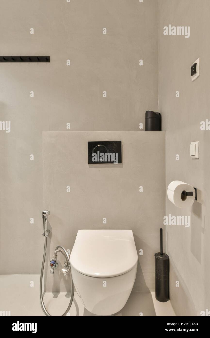 une salle de bains avec toilettes et pomme de douche fixée sur le mur à  côté est une image du visage d'un homme Photo Stock - Alamy