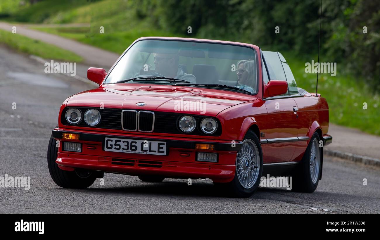 Stoke Goldington, Northants, Royaume-Uni - 14 mai 2023. 1990 rouge BMW série 3 voiture classique à travers un village anglais Banque D'Images