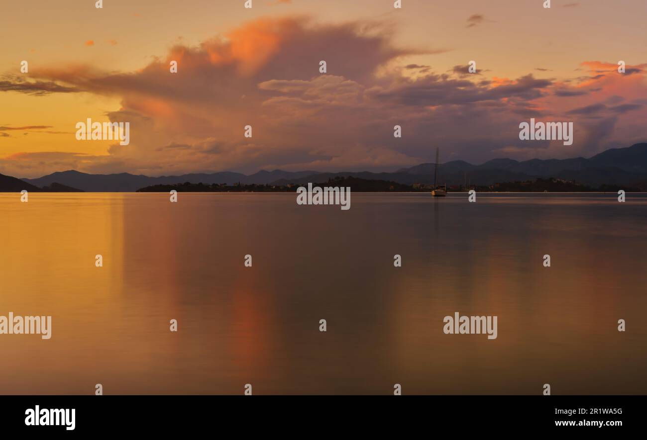 Soirée chaude en hiver, paysage de la baie de Fethiye. Longue exposition, vue floue de la mer et des montagnes illuminées par le soleil au coucher du soleil. Idée pour backgrou Banque D'Images