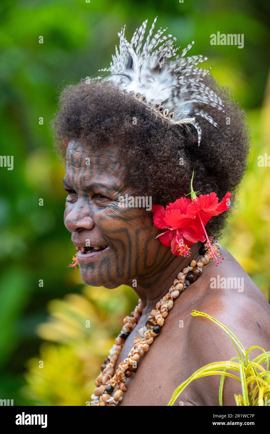 Papouasie-Nouvelle-Guinée, province d'Oro, île de Tufi, village de Baga. Un accueil traditionnel chantant. Vieille femme avec des tatouages typiques sur son visage. Banque D'Images