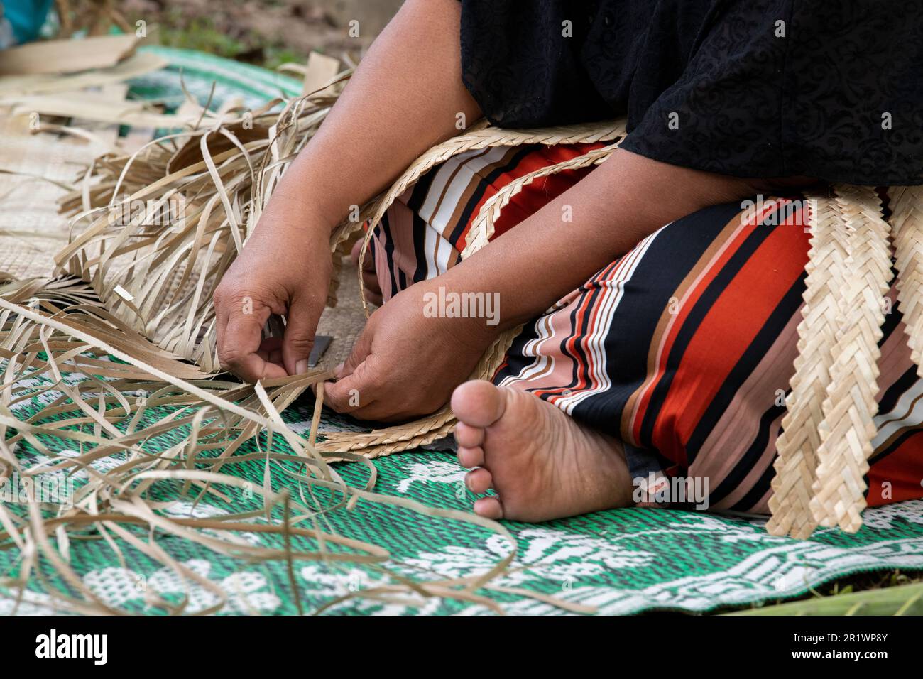 Royaume des Tonga, Neiafu. Femme locale tissage tapis de paille. Banque D'Images