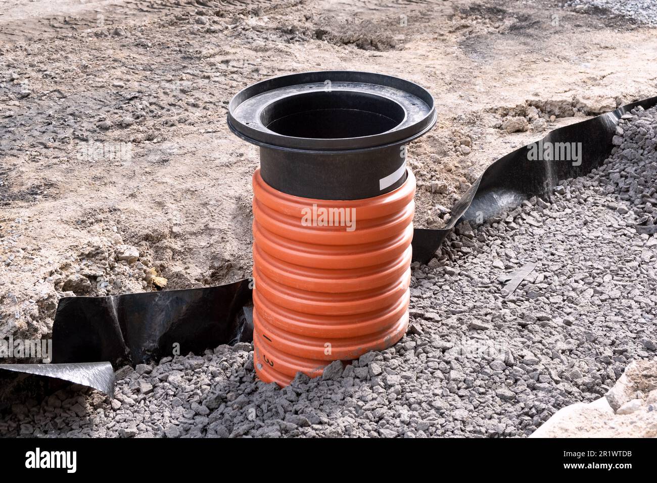 Le écloserie d'égouts a développé des tuyaux de drainage entre les zones résidentielles. Les gros tuyaux ondulés orange sont enterrés sous terre dans la rue. Nouvel égout sanitaire, Banque D'Images