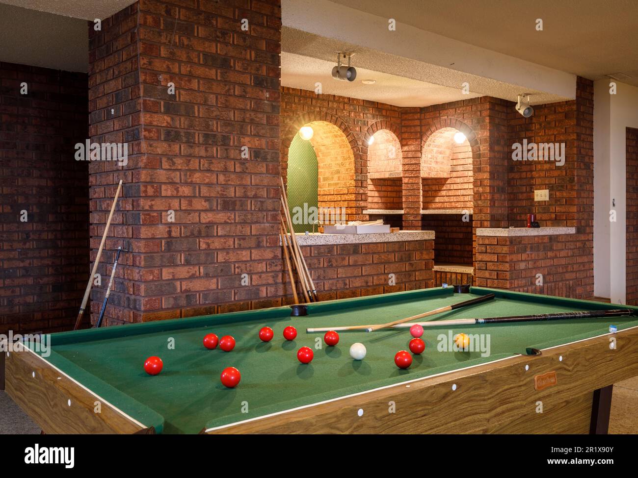Une table de billard avec un bar à la maison en arrière-plan dans le sous-sol d'une grande maison. Cette maison a depuis été démolie. Banque D'Images