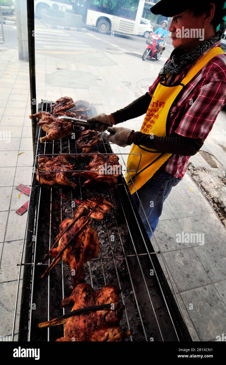 Un vendeur de nourriture de rue qui vend du poulet au barbecue à Bangkok, en Thaïlande. Banque D'Images