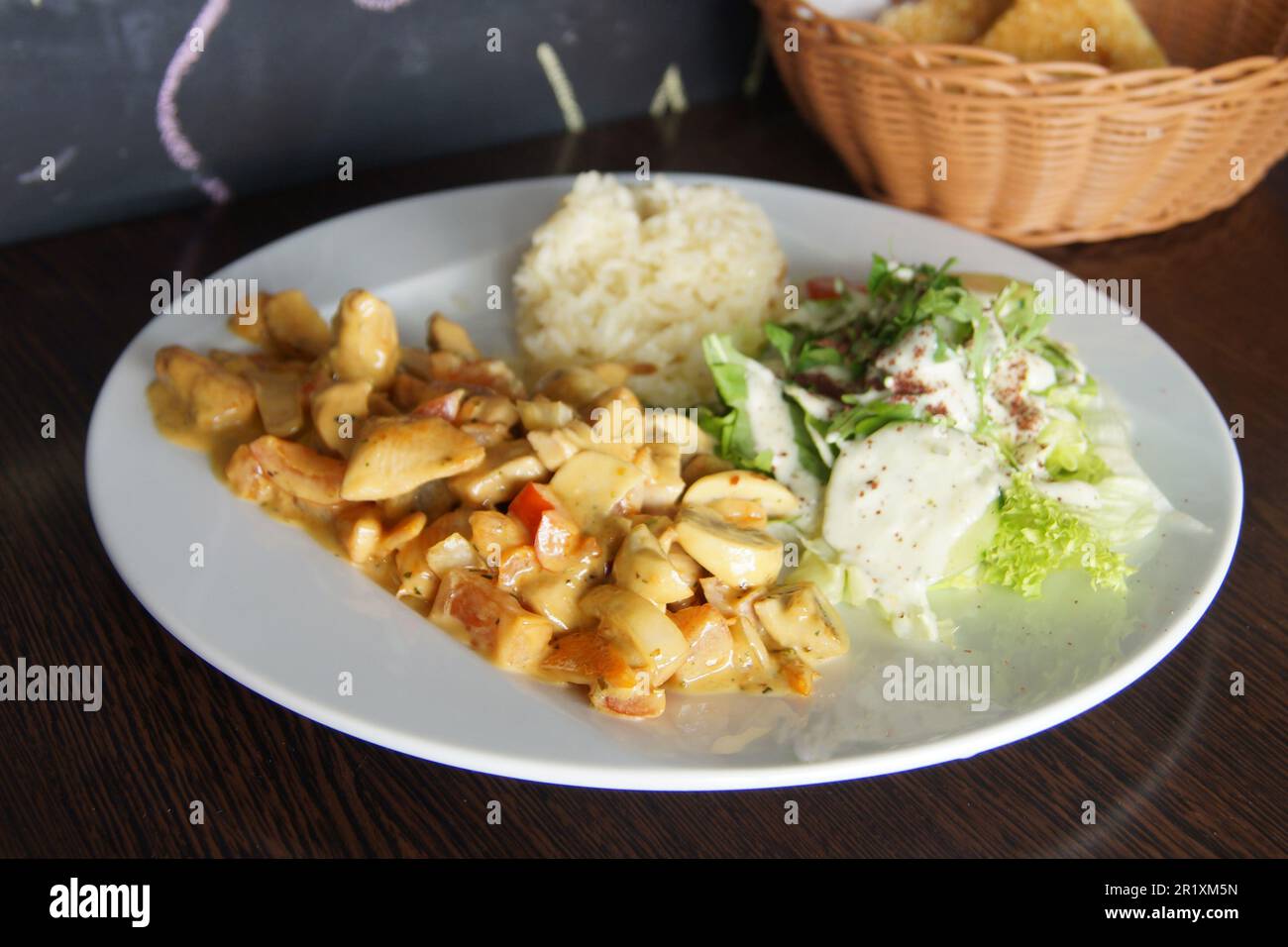 Poulet braisé avec légumes et un peu de riz et de salade. Banque D'Images