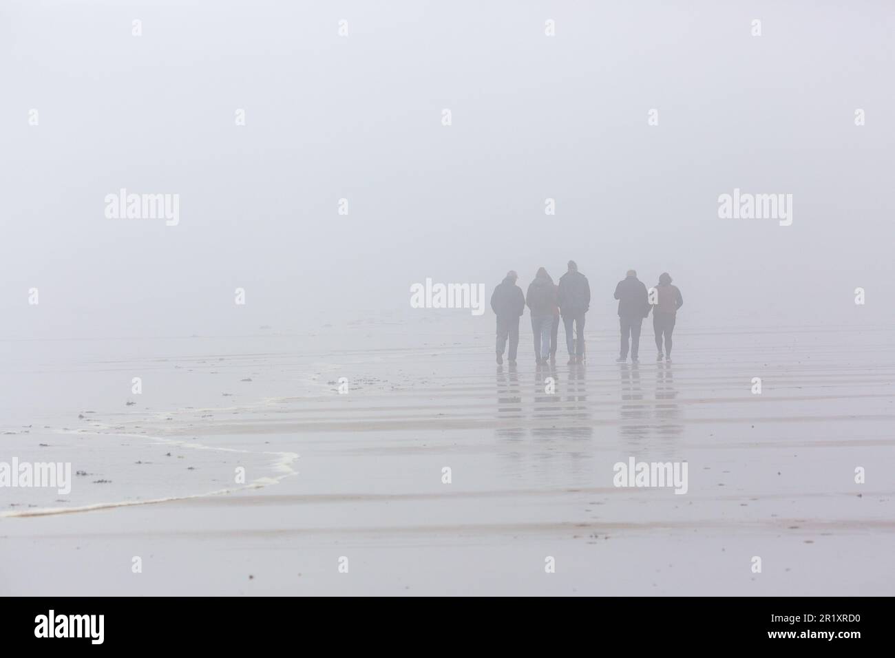 Personnes marchant sur une plage dans un brouillard épais dans le nord de Berwick Banque D'Images
