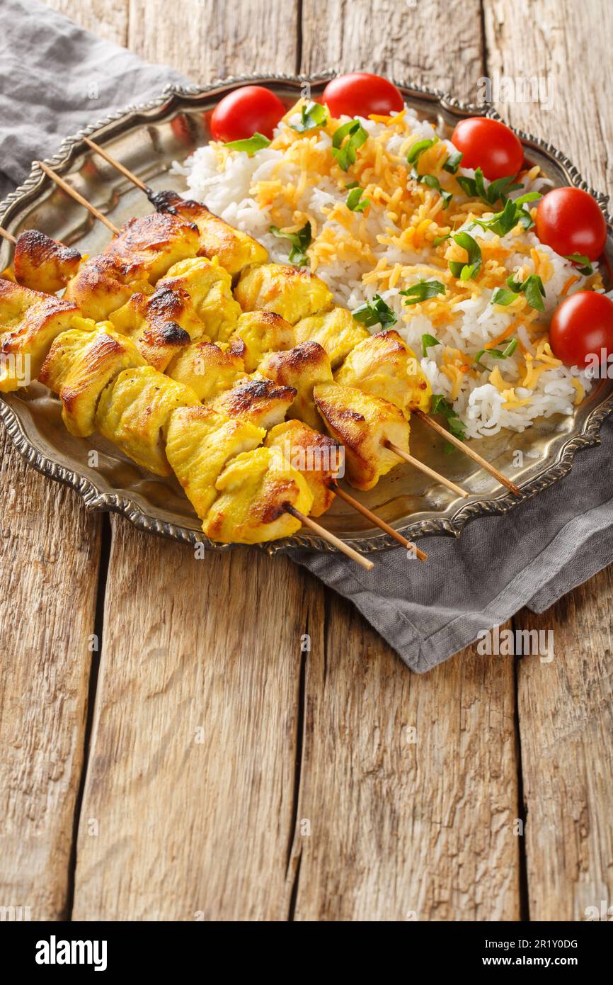 Le kebab de poulet grillé est connu sous le nom de kabab de jujeh avec du riz sur la plaque sur la table. Verticale Banque D'Images