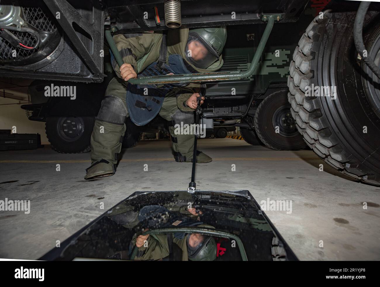 NANNING, CHINE - le 16 MAI 2023 - un agent d'élimination des explosifs inspecte le dessous d'une voiture avec un miroir d'inspection inférieur pendant un explosif Banque D'Images