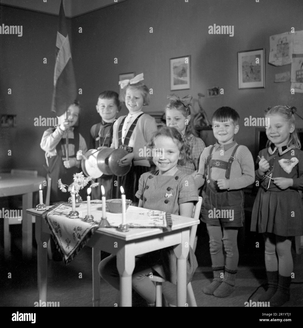 Anniversaire en 1940s. La fille d'anniversaire est assise à un bureau décoré de cinq bougies allumées, c'est son cinquième anniversaire. Un groupe de ses amis sont debout dans le dos chantant et jouant pour elle. La photo est prise à l'école maternelle de Stockholm avec des enfants âgés de 4-6 ans. Suède 1947. Conard réf. 882 Banque D'Images