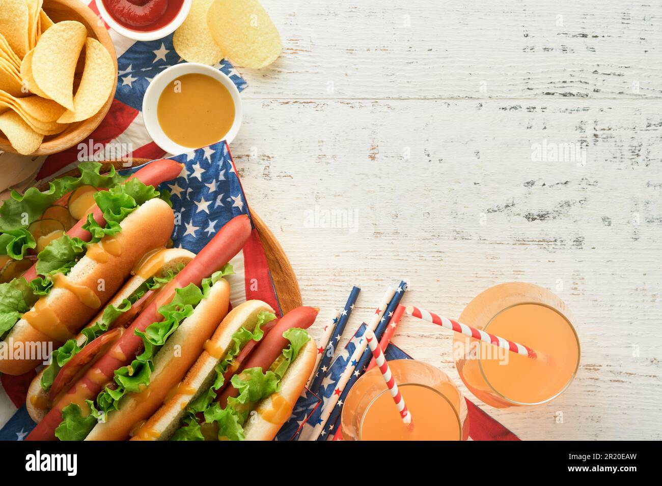 4th de juillet American Independence Day cuisine traditionnelle de pique-nique. Hot dog avec chips de pomme de terre et cocktail, drapeaux américains et symboles de USA Patriotic pi Banque D'Images