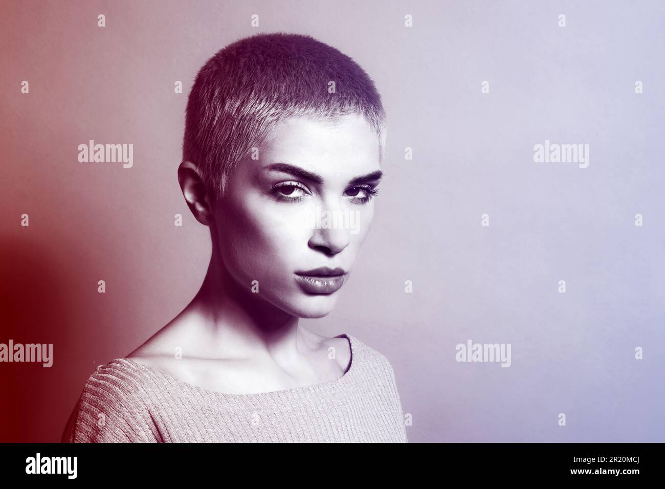 Portrait d'une jeune femme sérieuse modèle avec des cheveux courts regardant l'appareil photo contre l'arrière-plan du studio Banque D'Images