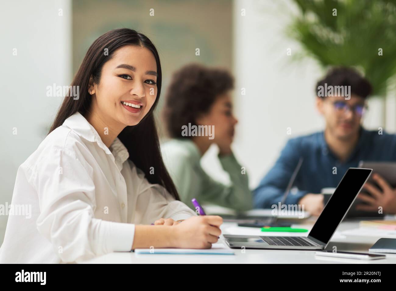 Asian Lady utilisant un ordinateur portable assis à une réunion d'entreprise au bureau Banque D'Images