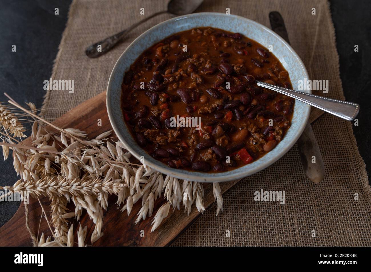 Ragoût de haricot avec du bœuf haché, cuit, haricots, poivrons, oignons, herbes à l'ail, tomates sur une assiette Banque D'Images