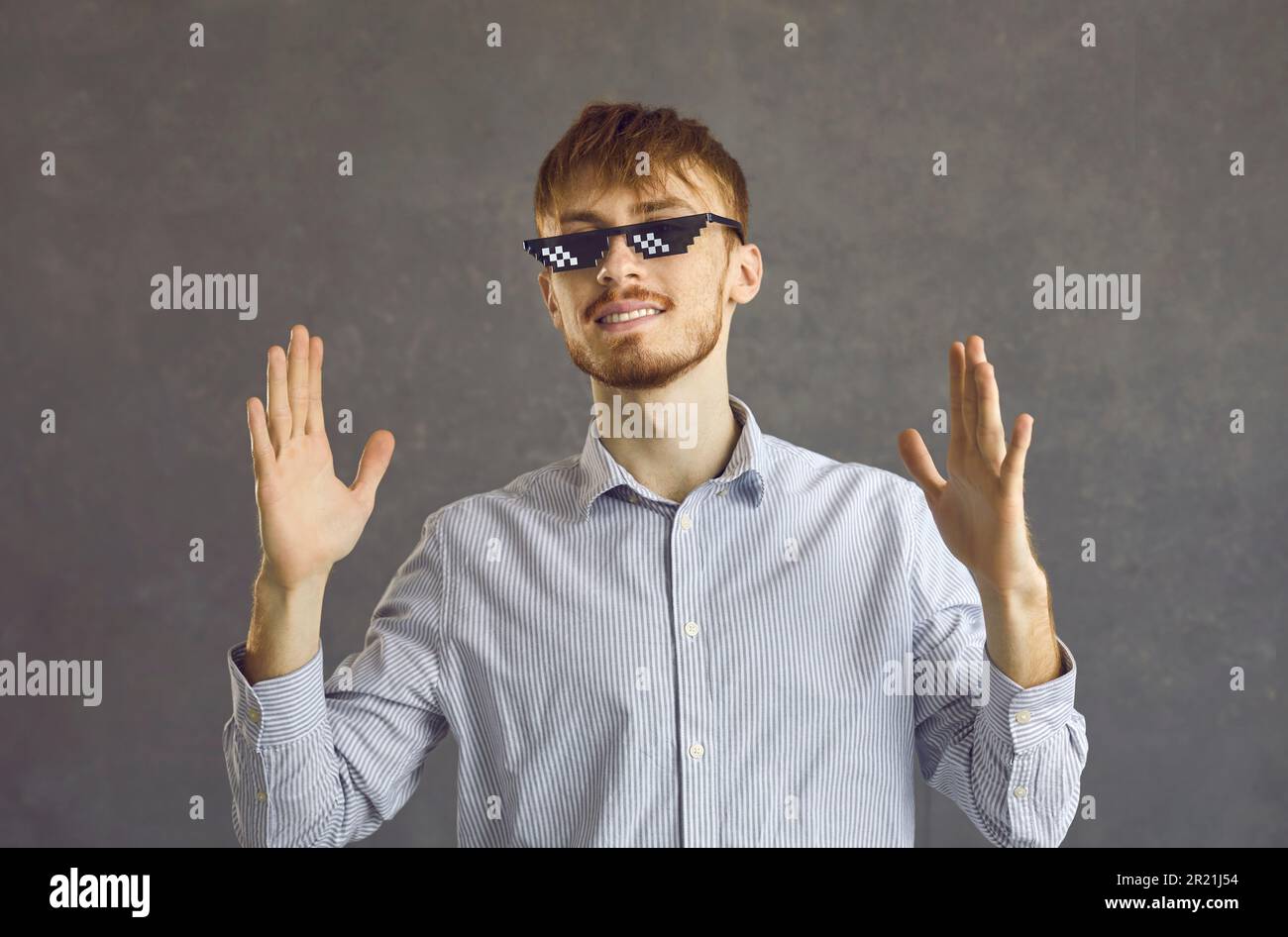 Studio portrait de jeune homme heureux dans des verres de vie de voyou debout sur fond gris Banque D'Images