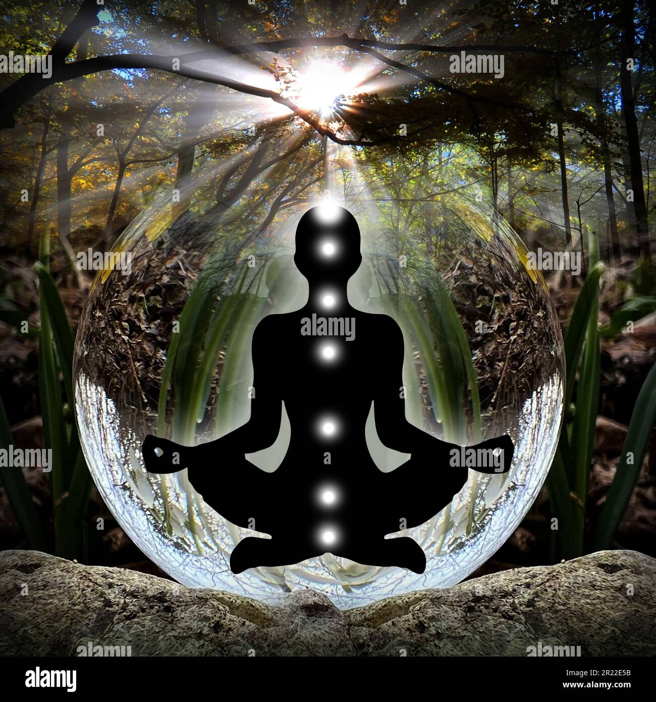Silhouette humaine dans le yoga, pose de lotus (corps d'énergie humaine, aura) devant le Lensball (boule de cristal) Banque D'Images