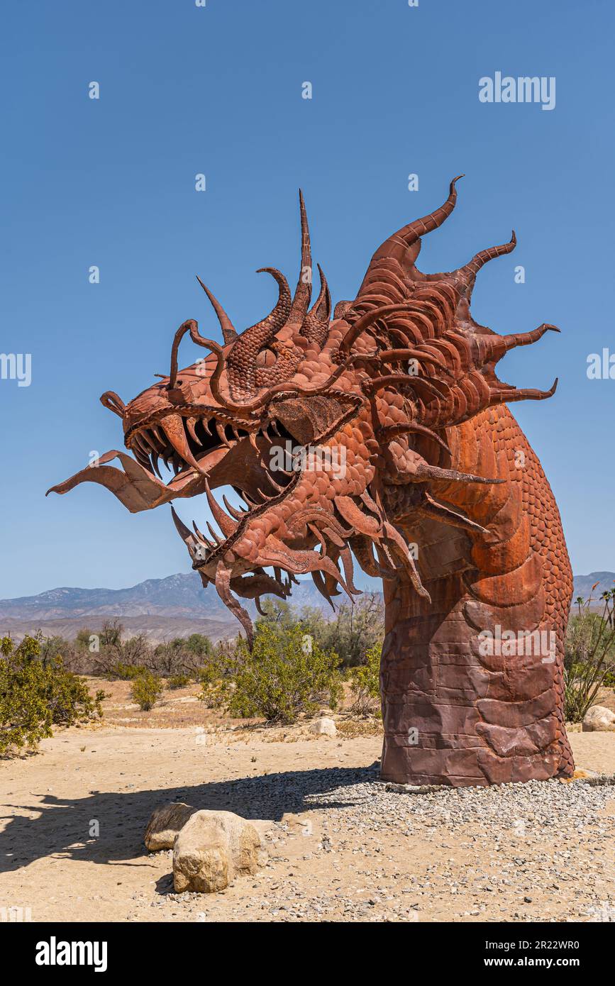 Borrego Springs, CA, Etats-Unis - 24 avril 2023: Portrait, statue de dinosaure de serpent géant préhistorique en métal rouillé brun, tête de côté, sur un désert sablonneux sous Banque D'Images