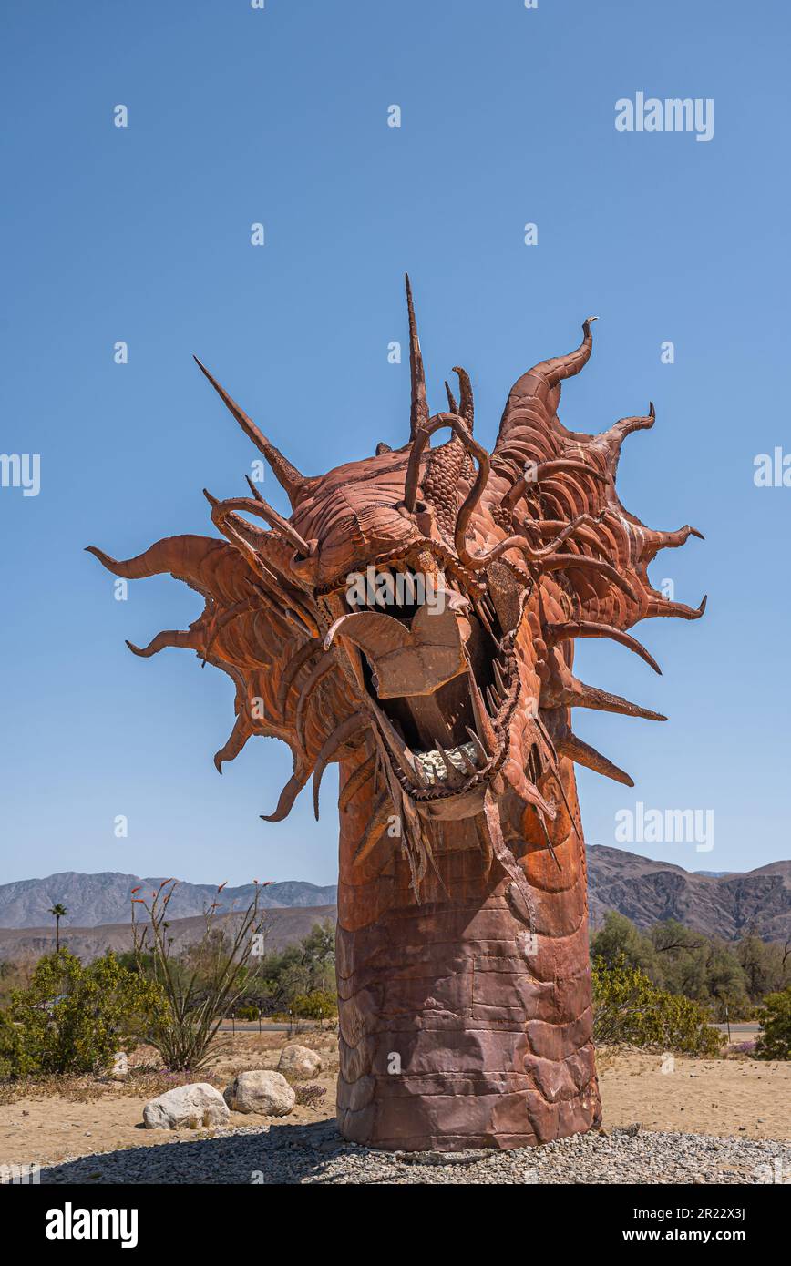Borrego Springs, CA, Etats-Unis - 24 avril 2023: Portrait, statue de dinosaure de serpent géant préhistorique en métal rouillé brun, tête frontale complète, sur un désert sablonneux Banque D'Images