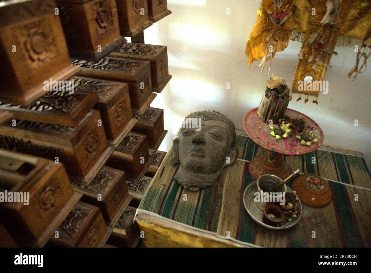Une sculpture, un ensemble de balinais offrant des équipements et des boîtes en bois contenant de vieux manuscrits de feuilles de palmier balinais au musée Gedong Kirtya à Singaraja, Buleleng, Bali, Indonésie. "Il n'y a qu'un accès limité au contenu des manuscrits, en raison des difficultés linguistiques et de la fragilité du document", a écrit une équipe de scientifiques dirigée par Made Windu Antara Kesiman du Laboratoire informatique image interaction (L3i), Université de la Rochelle, Lors de la Conférence internationale sur les frontières en 15th sur la reconnaissance de l'écriture manuscrite 2016, octobre 2016, à Shenzhen, Chine. Banque D'Images