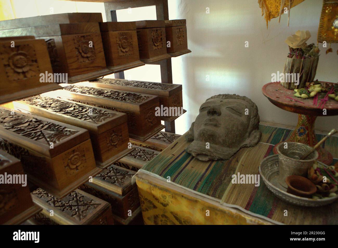 Une sculpture, un ensemble de balinais offrant des équipements et des boîtes en bois contenant de vieux manuscrits de feuilles de palmier balinais au musée Gedong Kirtya à Singaraja, Buleleng, Bali, Indonésie. "Il n'y a qu'un accès limité au contenu des manuscrits, en raison des difficultés linguistiques et de la fragilité du document", a écrit une équipe de scientifiques dirigée par Made Windu Antara Kesiman du Laboratoire informatique image interaction (L3i), Université de la Rochelle, Lors de la Conférence internationale sur les frontières en 15th sur la reconnaissance de l'écriture manuscrite 2016, octobre 2016, à Shenzhen, Chine. Banque D'Images