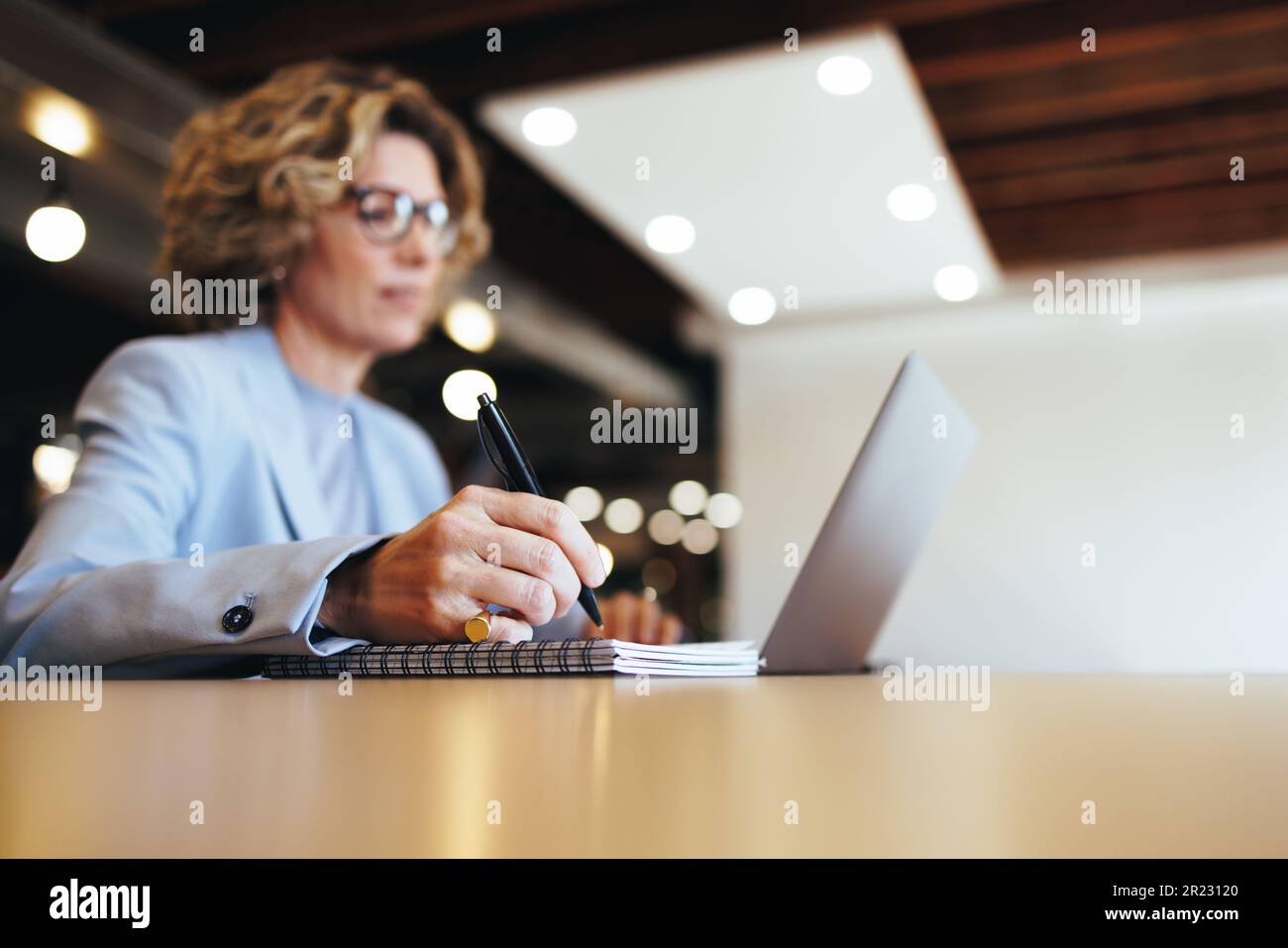 Concepteur professionnel créant une liste de tâches sur un bloc-notes au travail. femme d'affaires écrivant dans son journal dans un bureau de coworking. Femme d'affaires mature assis Banque D'Images