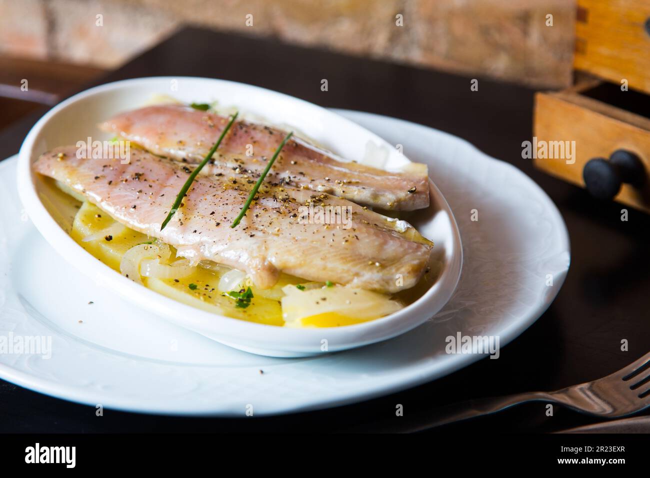 Filets de maquereau marinés sur des pommes de terre cuites au four. Banque D'Images