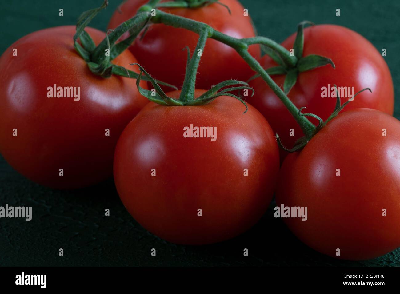 Un groupe de tomates de raisin sur fond vert, gros plan Banque D'Images