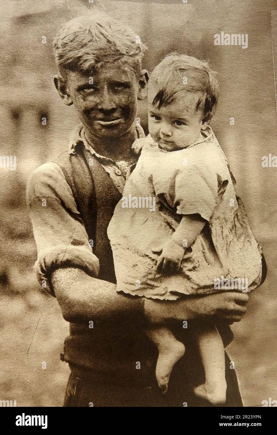 Pays de Galles en 1939 - Un portrait d'un mineur gallois des années 1930 et d'un enfant, montrant des vêtements typiques de l'époque. Banque D'Images