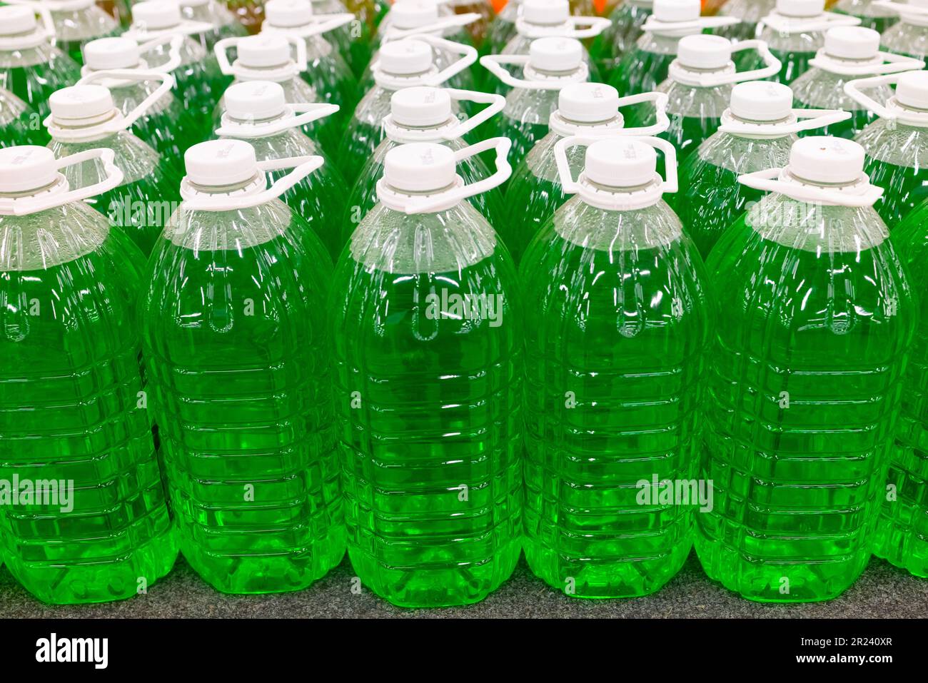 Fluide technique vert dans des bouteilles en plastique au supermarché. Banque D'Images