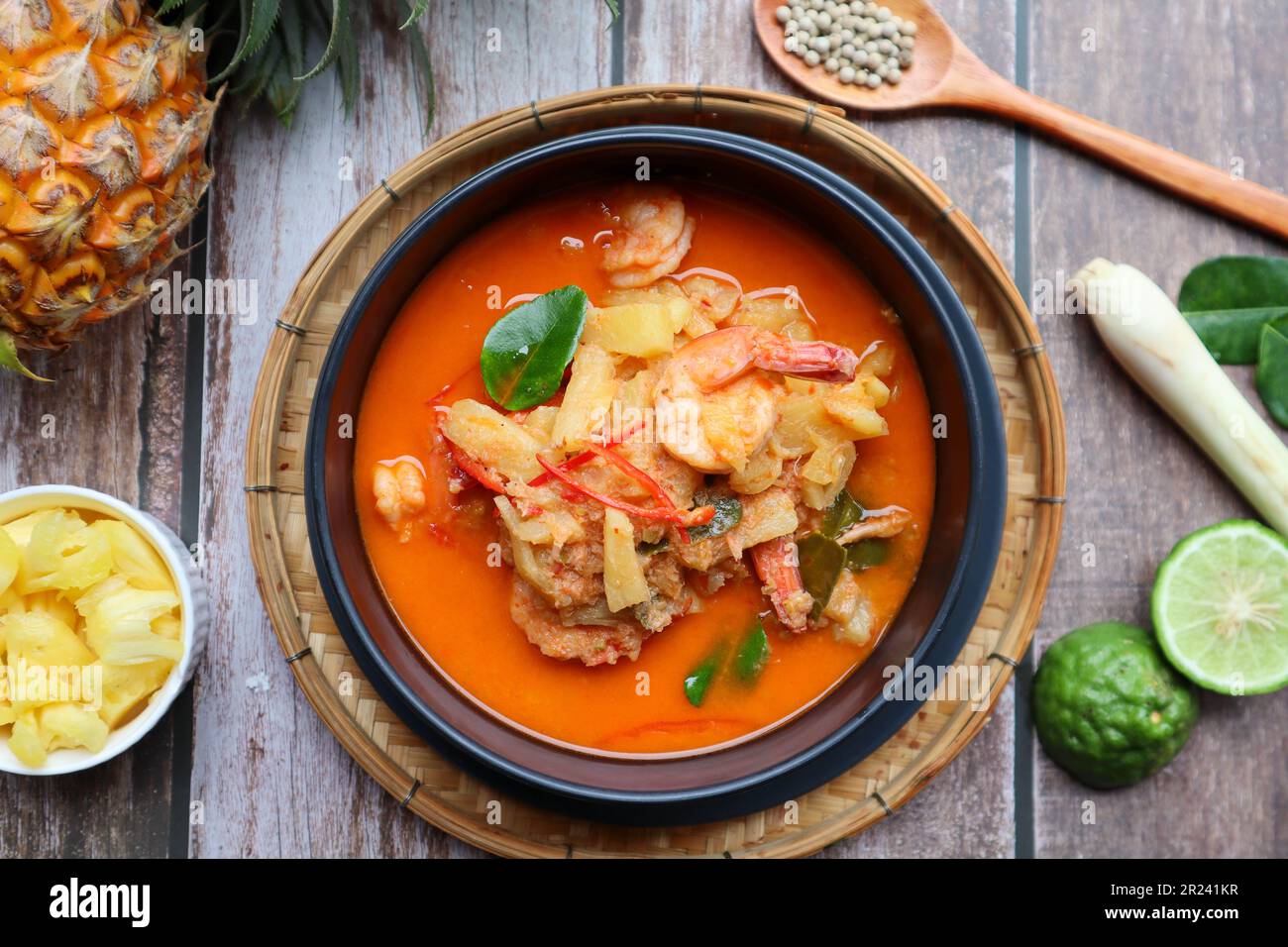 Curry rouge ananas et crevettes - cuisine thaïlandaise authentique appelée Kang Kua Supparos, vue de dessus sur une table en bois Banque D'Images