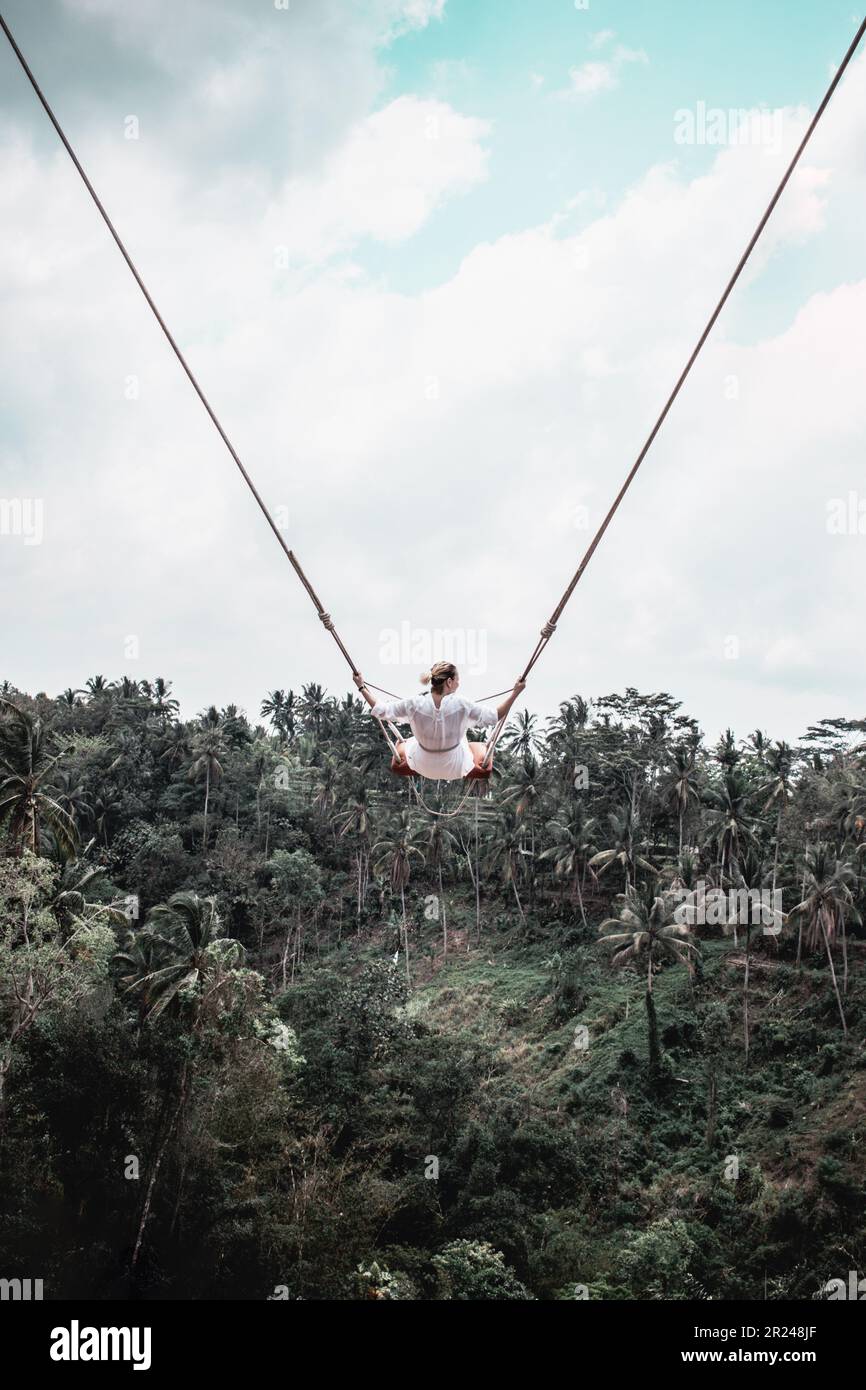 femme sur balançoire géante regardant au-dessus d'une forêt dense à bali  Photo Stock - Alamy