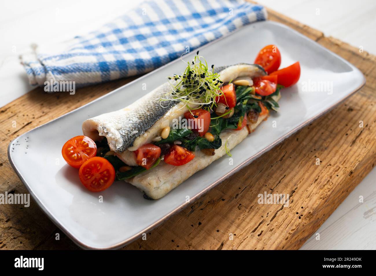 Filet de bar cuit farci d'épinards, de pignons de pin et de tomates cerises  Photo Stock - Alamy