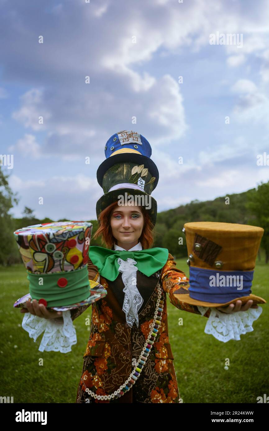 Belle femme en tant que mad hatter avec des chapeaux dans la nature Banque D'Images
