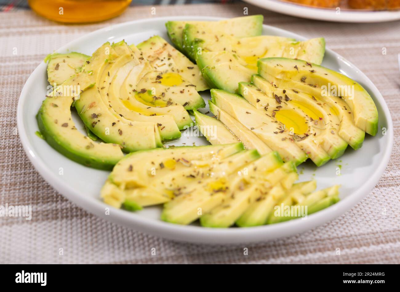 pulpe d'avocat mûre coupée en morceaux saupoudrée de jus de citron sur une assiette Banque D'Images